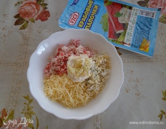 В чашку к сыру и яйцу добавляем измельченные крабовые палочки, майонез и измельченный чеснок.