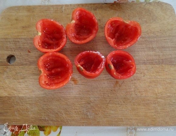 С помощью ложки вынимаем мякоть из половинок помидор.