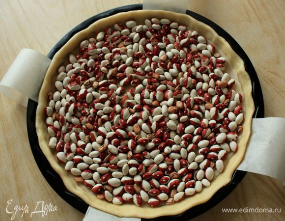 Высыпать в форму фасоль и выпекать 10 минут, затем удалить фасоль с пергаментом и запекать еще 5 минут, пока основание пирога не будет выглядеть достаточно сухим.
В это же время выложить на противень половинки пекана и слегка поджарить их в духовке (5-8 минут).
Уменьшить температуру в духовке до 180°С, с конвекцией 160°С.
