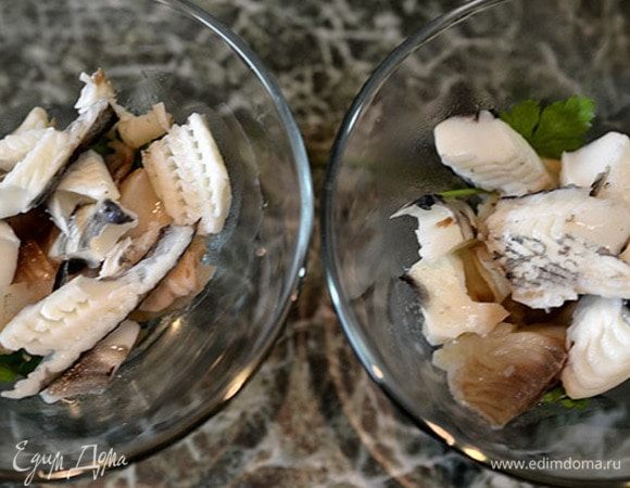 В креманки или бокалы выложить листки зелени, затем слоями разную рыбу. 