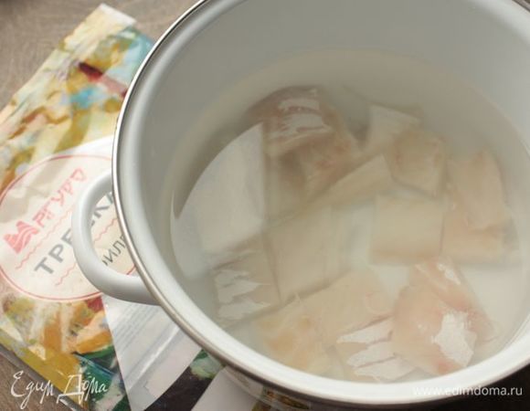 Нарежьте филе трески на небольшие кусочки, залейте водой и поставьте на средний огонь. Как только рыба закипит, удалите образовавшуюся пену и варите ее на медленном огне в течение 10 минут. После чего аккуратно достаньте из бульона и переложите в отдельную емкость.