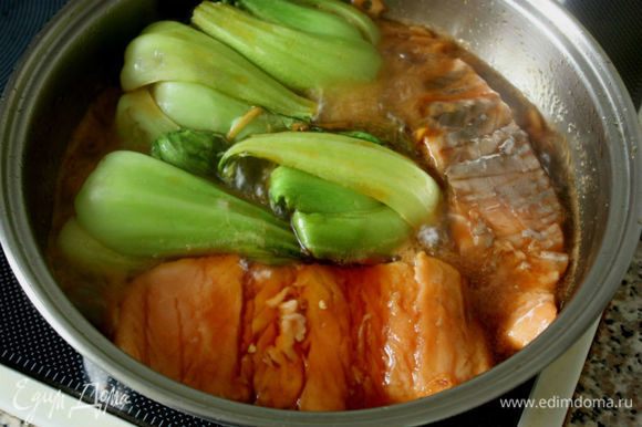 Положить рыбу в кипящий соус, уменьшить огонь, затем добавить капусту срезами вниз. Готовить еще 3-5 минут. (Выбирайте сковороду попросторнее!)