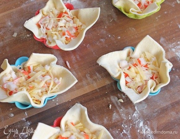 Уложить, каждый квадрат, в формы. Сверху плотненько начинку.