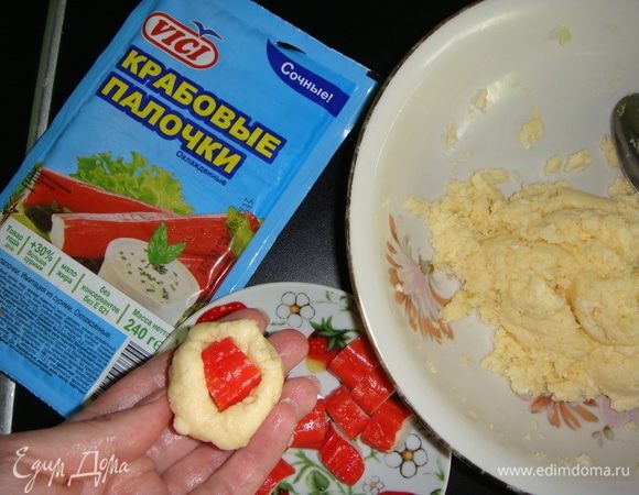Крабовые палочки ТМ VICI нарезать брусочками. Сыр аккуратно перемешать с белками. Берем 1 чайную ложку сырной смеси и формируем руками шарик, внутрь кладем один брусочек крабовой палочки, защипываем края и скатываем шарик.