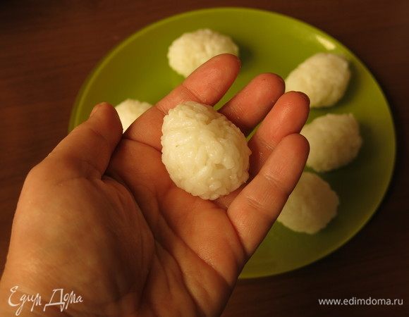 Рис разделим на шесть частей и скатаем шарики, руки предварительно смочив водой.