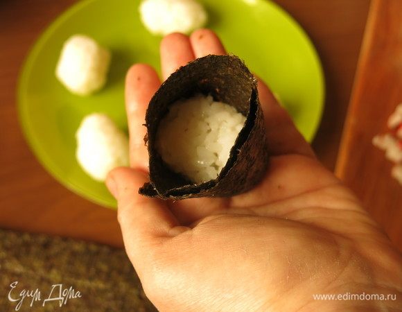 Каждый шарик делаем более плоским, заворачиваем нори так, чтобы рис был у основания листа.