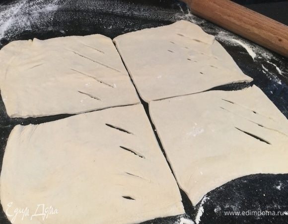 Тесто немного раскатайте, разделите на 8 квадратов. С одной стороны каждого квадрата сделайте небольшие надрезы.