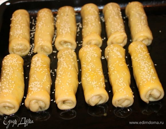 Выложить рулеты на смазанный маслом противень. Можно смазать желтком и посыпать кунжутом.