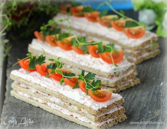 Сложить хлебцы с паштетом по 3 штуки, украсить четвертинками черри и зеленью.
