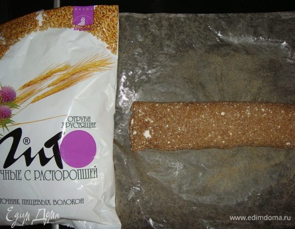 С помощью пергамента свернуть тесто в рулет, начиная со стороны с начинкой.