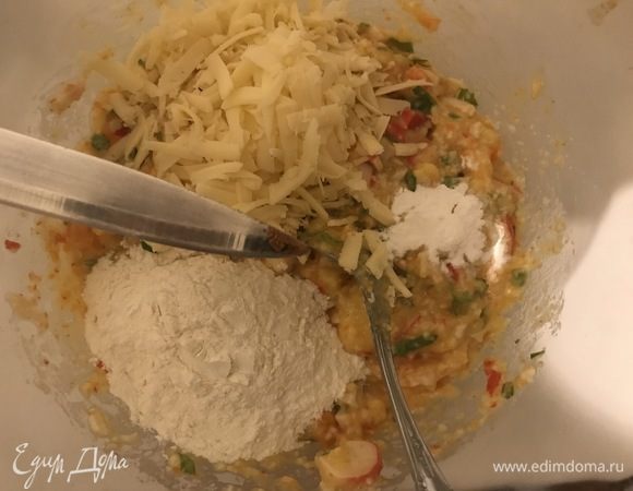 Половину сыра добавить в полученную смесь овощей и крабового мяса, всыпать муку, разрыхлитель и мускатный орех на кончике ножа. Все перемешать.