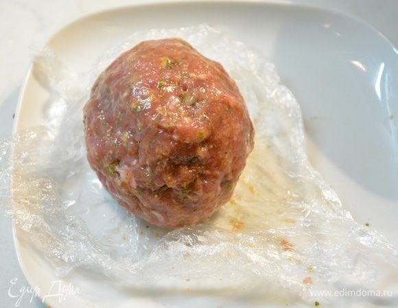 Сформировать мясной шарик. Если мясо липнет к руке и рвется, смочите руки холодной водой. Завернуть мясной шарик в пленку и убрать в морозильник на 5-7 минут. Тем временем достаньте из морозильной камеры другой грибной шарик и повторите шаги 10-11. У вас должно получится 4 мясных шарика с начинкой.