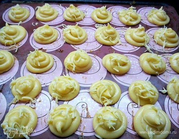 Перекладываем тесто в кондитерский мешок и отсаживаем профитроли на силиконовый коврик или бумагу для выпечки (предварительно бумагу смазываем растительным маслом) на небольшом расстоянии друг от друга. Верх посыпаем тертым на мелкой терке пармезаном.
