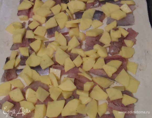 Картофель очищаем, нарезаем небольшими ломтиками. Раскладываем на рыбу и заполняем промежутки. Немного солим.