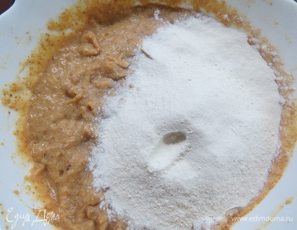 В отдельной миске соединить цельнозерновую пшеничную и цельнозерновую рисовую муку, разрыхлитель, соду. Просеять мучную смесь в тесто и аккуратно перемешать. Вымешивать надо тщательно, тогда корж получится более воздушным. 