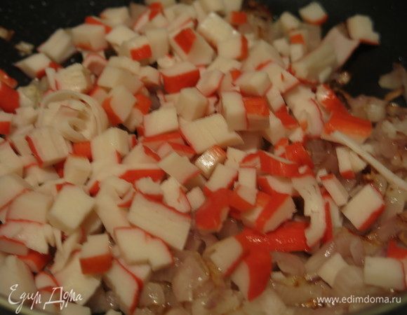 Кладем палочки к луку, обжариваем 2 минуты.