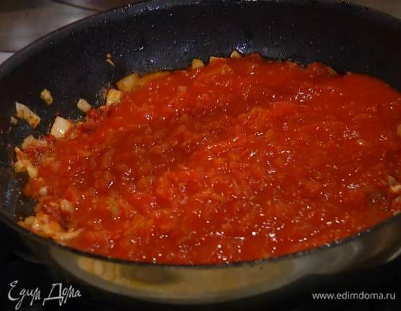 Выложить к луку с чесноком томатную пасту, перемешать, затем добавить помидоры в собственном соку и все прогреть.