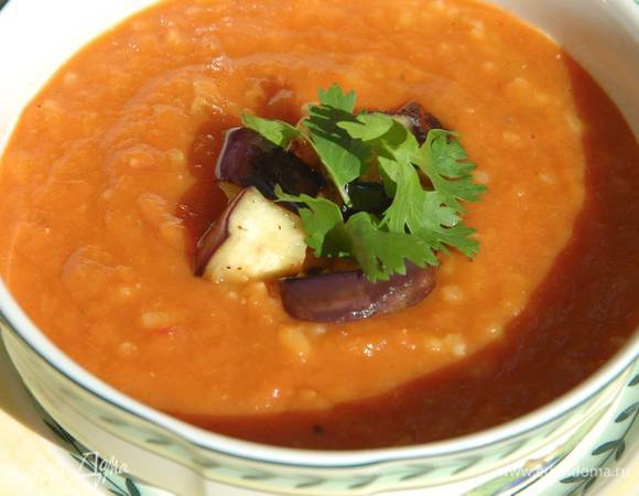Готовый суп разлить в тарелки, выложить обжаренные баклажаны и украсить листьями кинзы.