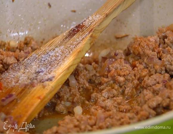 Добавить в фарш томатную пасту, слегка посолить, поперчить, всыпать сахар, кедровые орехи и, помешивая, обжаривать еще несколько минут.