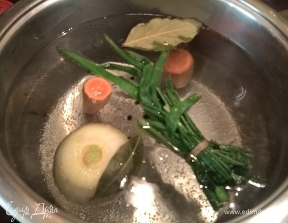 Займемся бульоном. Кастрюлю с водой ставим на огонь и, когда вода закипит, бросаем в нее 1 крупную морковку, корень петрушки (желательно, но не обязательно) и 1 крупную луковицу (предварительно очищенную), перец-горошек и лавровый лист. У меня корня петрушки не оказалось, но имеется в наличии замороженные кусочки стеблей сельдерея. Добавила немного в качестве эксперимента — получилось хорошо. Но с сельдереем главное не перестараться:) У пучков зелени отрезаем стеблевую часть, обматываем стебли ниткой и добавляем туда же, в бульон. Даем закипеть и убавляем огонь.