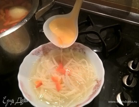 Помещаем в глубокую емкость, выжимаем в него лимонные дольки и через пяток минут заливаем кипящим бульоном. Таким образом мы убираем горечь, но сохраняем упругость. В конце приготовления этот бульон мы вернем обратно в уху. Внимание! Эту манипуляцию лучше совершать только с белым луком. Если у вас лук синий, в кипящем бульоне он приобретет неприятно синюшный цвет.