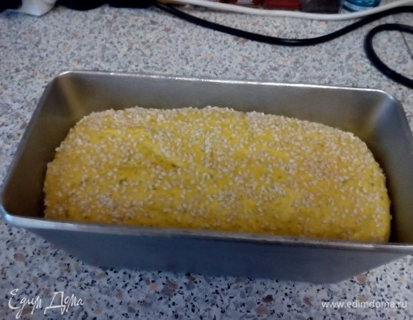 Смазать оливковым маслом форму. Обмять тесто и поместить в форму. Оставить «отдыхать» на ~40 минут (на 20 минуте обсыпать кунжутом, чтобы он успел приклеится к хлебу).