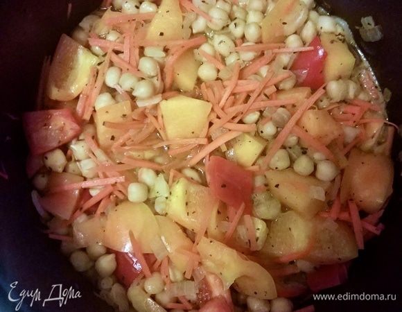 К луку добавляем готовый нут, протертые томаты и все овощи, кроме шпината (его очередь придет позже), заливаем водой и тушим минут 10–15, пока овощи не станут мягкими. 