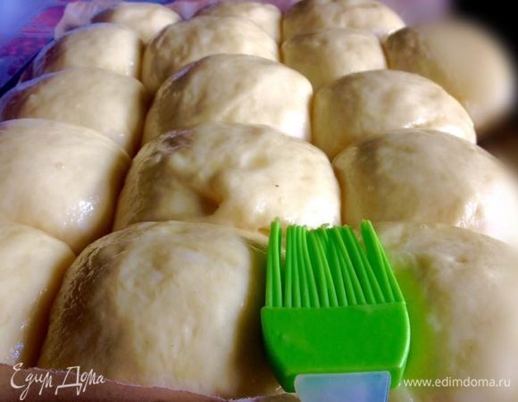 На этом фото видно как булочки увеличились в объеме, смазаны и уже готовы к выпечке.