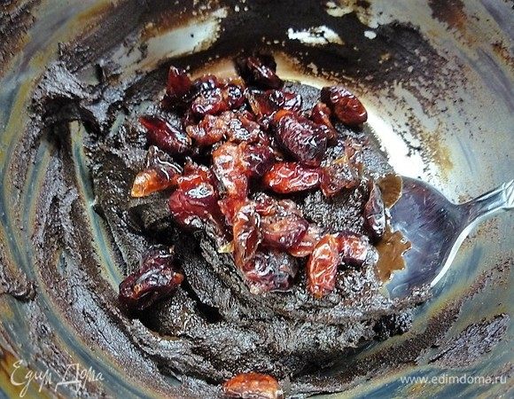 Убираем с огня и всыпаем в горячую шоколадную массу сушеную вишню, перемешиваем.