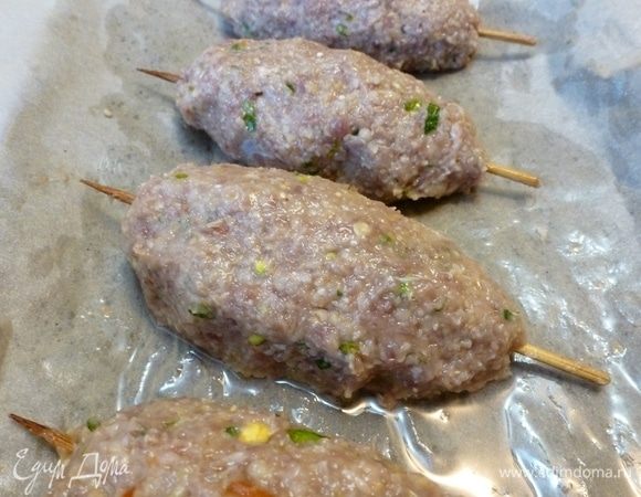 Включить духовку на разогрев на 200°С. Из фарша сформировать продолговатые котлетки. Насадить их на шпажки. На промасленную бумагу для выпечки выложить люля-кебабы. Запекать в разогретой духовке с одной стороны 15 минут.