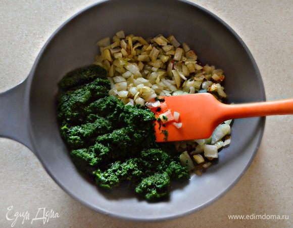 Тем временем на оливковом масле обжарить раздавленные зубчики чеснока. Чеснок после этого нужно выкинуть. Добавить к полученному чесночному маслу нарезанный мелко лук и пассеровать до золотистого цвета. Добавить размороженный и отжатый шпинат, посолить, поперчить и протушить пару минут.