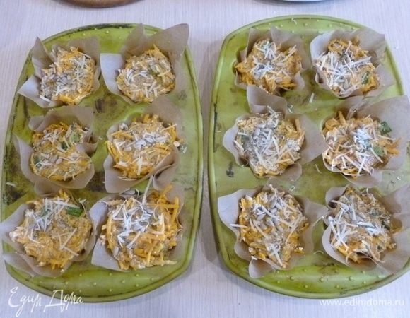 Выложить в формы для маффинов квадратики пергамента (или формочки для маффинов). Разложить тесто по формочкам. Сверху натереть пармезан, посыпать семечками и маком. 