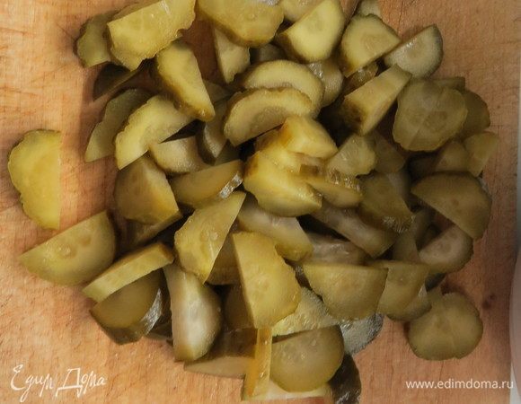 Маринованные огурцы порезать полукружочками, добавить все в казан и обжаривать на сильном огне 2–3 минуты, затем огонь убавить и тушить минут 5.