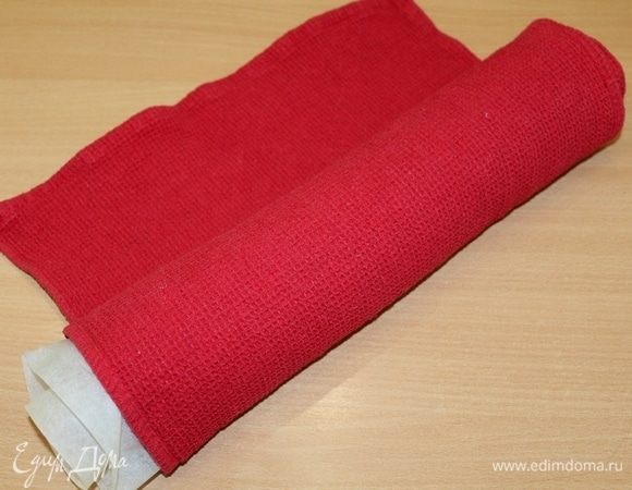 Вынуть корж из духовки. На кухонное полотенце переворачиваем готовый корж. Аккуратно сворачиваем его в рулет вместе с бумагой. Оставляем до полного остывания.


