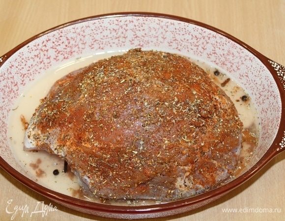 Мясо нашпигуйте оставшимся чесноком, натрите мясо специями, налейте немного маринада в форму для запекания.