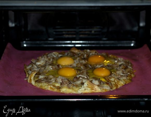 Выложить бекон на запеченную основу. Аккуратно добавить 4 яйца.  Запекать 12 минут при 200°С.