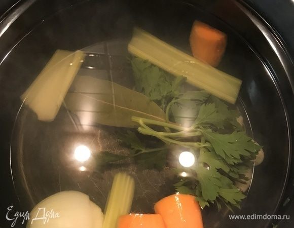 Сначала приготовим овощной бульон. В кастрюлю наливаем 1,5 л воды. И ставим на огонь. Тем временем очищаем 1 морковь и режем произвольно. Стебель сельдерея также режем крупно. Добавляем все в закипающую воду вместе с одной луковицей и зеленью сельдерея. Солим по вкусу и не забываем про перец горошком. Оставляем вариться.