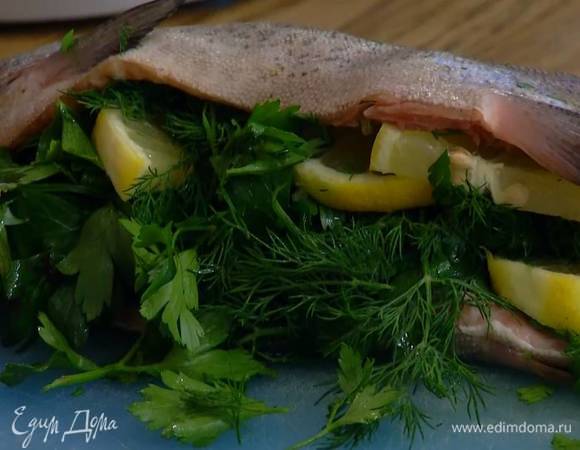В брюшко форели поместить листья петрушки, укропа и нарезанный лимон.
