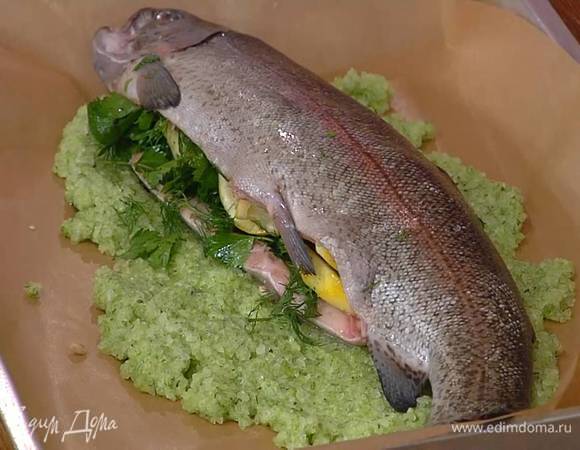 Глубокий противень выстелить бумагой для выпечки, равномерно распределить треть ароматной соли, выложить рыбу, покрыть ее оставшейся зеленой смесью и плотно прижать соль руками.