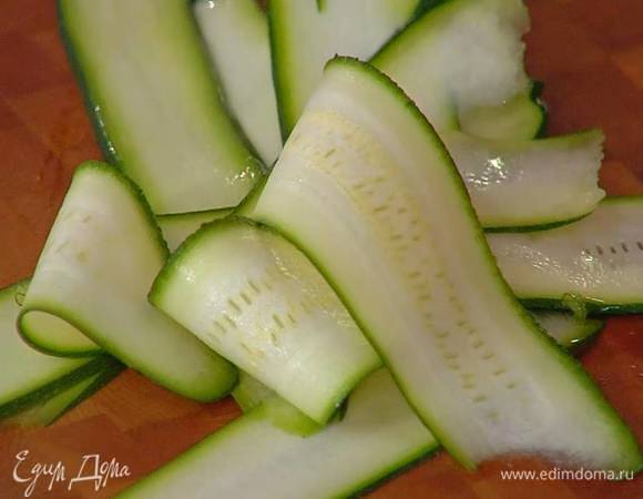 Цукини нарезать вдоль очень тонкими полосками (можно воспользоваться овощечисткой).