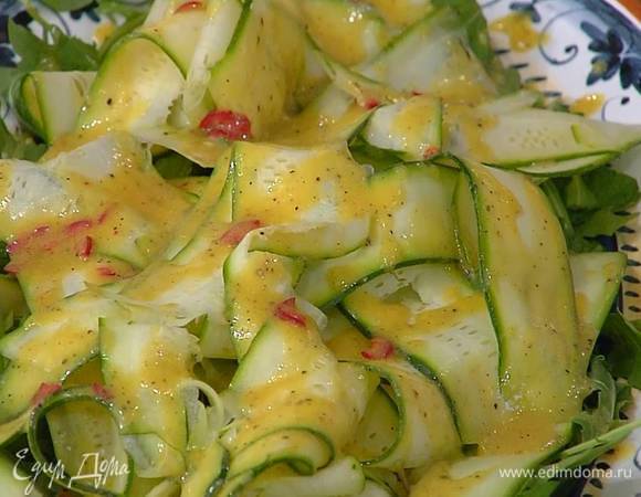 Руколу выложить на блюдо, посыпать измельченной руками мятой, сверху разложить полоски цукини и полить все заправкой.