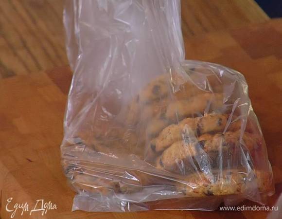 Печенье поместить в полиэтиленовый пакет и измельчить скалкой в мелкую крошку, затем всыпать его в растопленное сливочное масло и все перемешать.