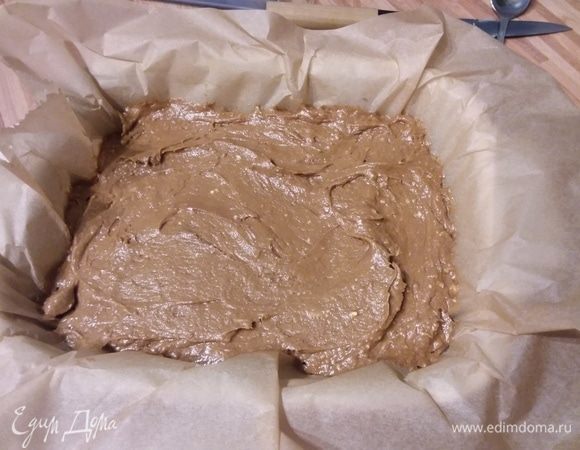 Взбить сахар с яйцами и размягченным маслом до однородности. Растворимый кофе развести водой и влить в тесто, размешать. Смешать муку с разрыхлителем и какао и вмешать в тесто. Форму (у меня 30×21 см) выстлать пергаментной бумагой и выложить тесто. Разровнять. 