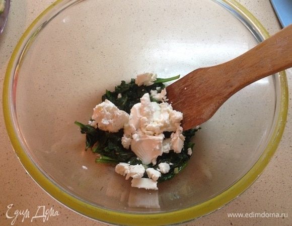 Выложить шпинат миску. Добавить мягкий творог.