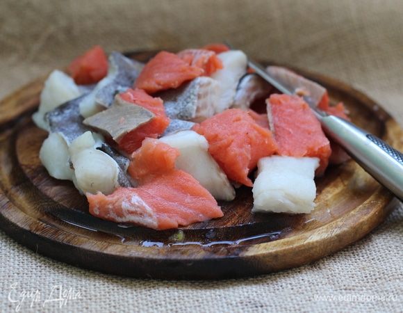 Треску (или любую другую рыбу, у меня были треска, палтус и лосось) порезать кусочками около 3 см. Затем засыпать перец, тимьян, орегано, петрушку и нарезанный кубиками картофель. Жарить в течение еще 2 минут, после чего влить вино, включить максимальный огонь и готовить, пока не уменьшится в объеме вдвое.