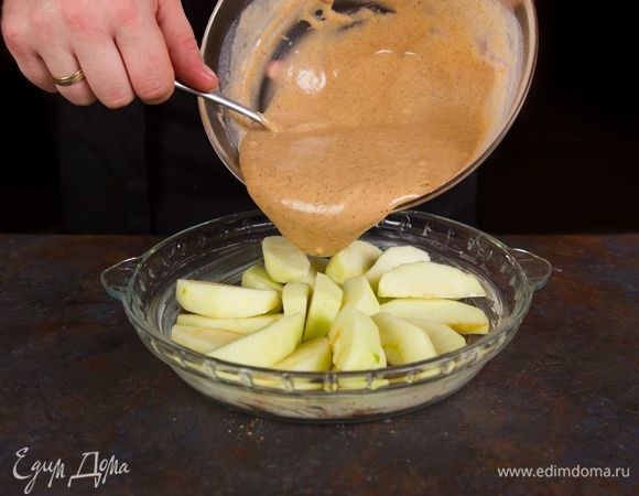 Форму для выпечки смажьте сливочным маслом. Выложите нарезанные яблоки ровным слоем и залейте равномерно тестом. 
