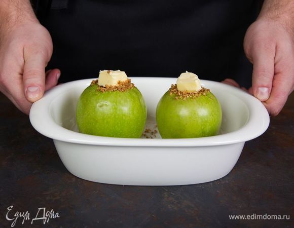 В каждое яблоко положите немного сахарно-ореховой смеси, а сверху — кусочек сливочного масла. Поместите яблоки в глубокую емкость для микроволновки. 