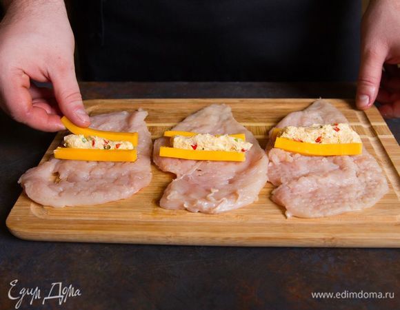 Выложите на каждый кусочек куриного филе полученную смесь и сыр.