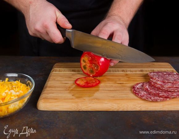 Нарежьте кружочками салями, помидоры, а сыр натрите на терке.