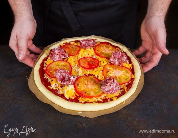 Выложите на тесто колбасу, помидоры, посыпьте сыром (используем половину).